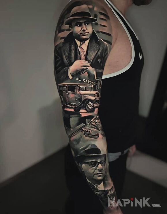 Tattoo La mafia in faces motif and realistic style on the upper arm