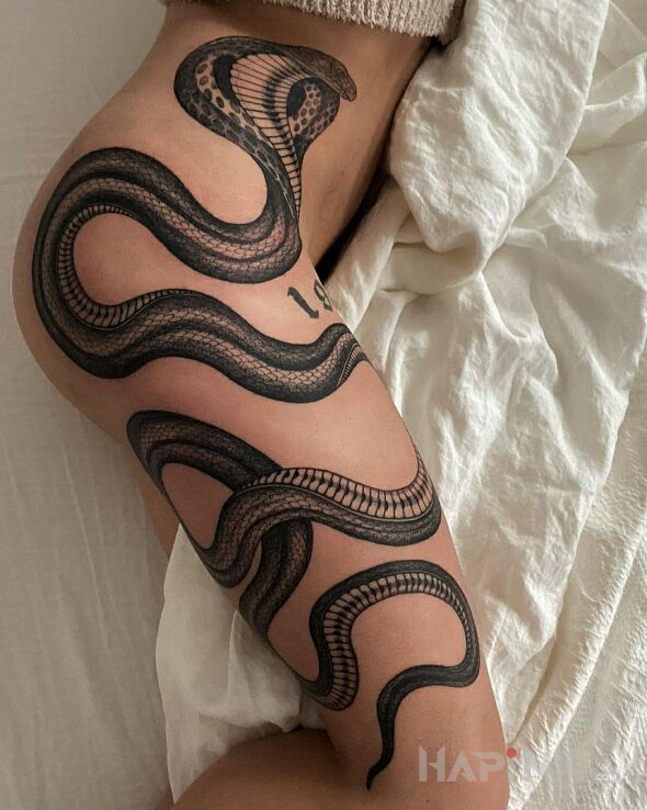 Tattoo Kobra dobra in black and gray motif and realistic style on the thigh