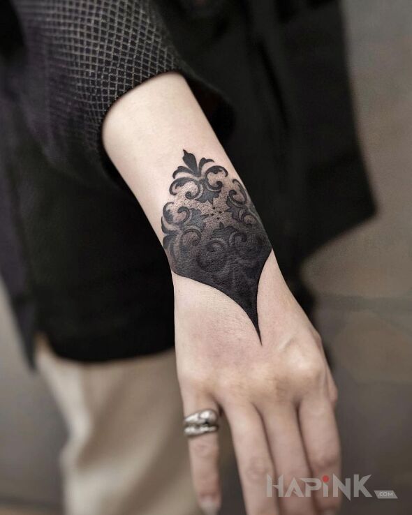 Tattoo Ozdobiony nadgarstek in black and gray motif and blackwork / blackout style On the arm