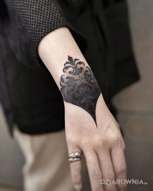 Tatuaż ozdobiony nadgarstek w motywie czarno-szare i stylu blackwork / blackout na ramieniu