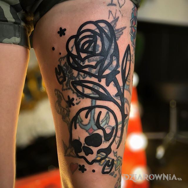 Tatuaż mocno zarysowana dziara w motywie kwiaty i stylu blast over na udzie