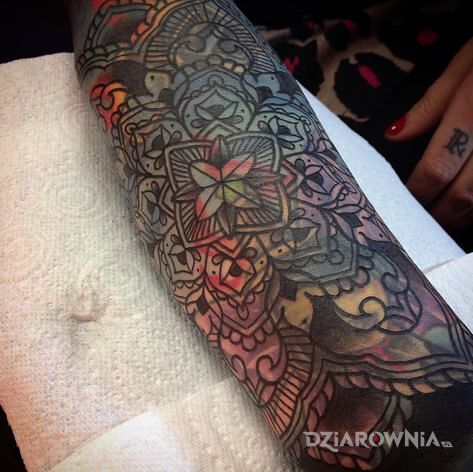 Tatuaż mandala na kolorowym tle w motywie mandale i stylu blast over na przedramieniu