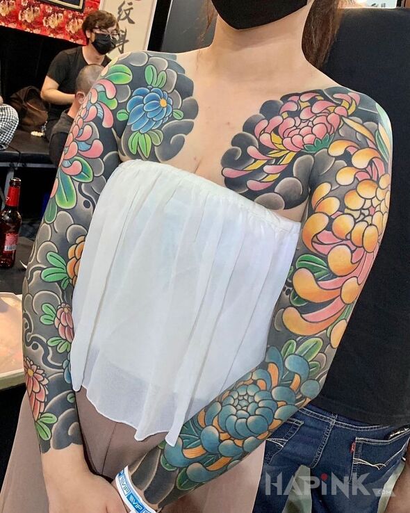 Tattoo Kwiaty na modłę japońską in colorful motif and japanese / irezumi style on the upper arm