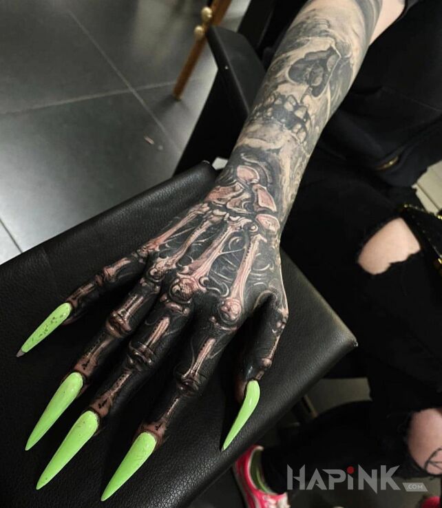 Tattoo Koścista rączka i neonowe pazury in anatomical motif and realistic style on the hand