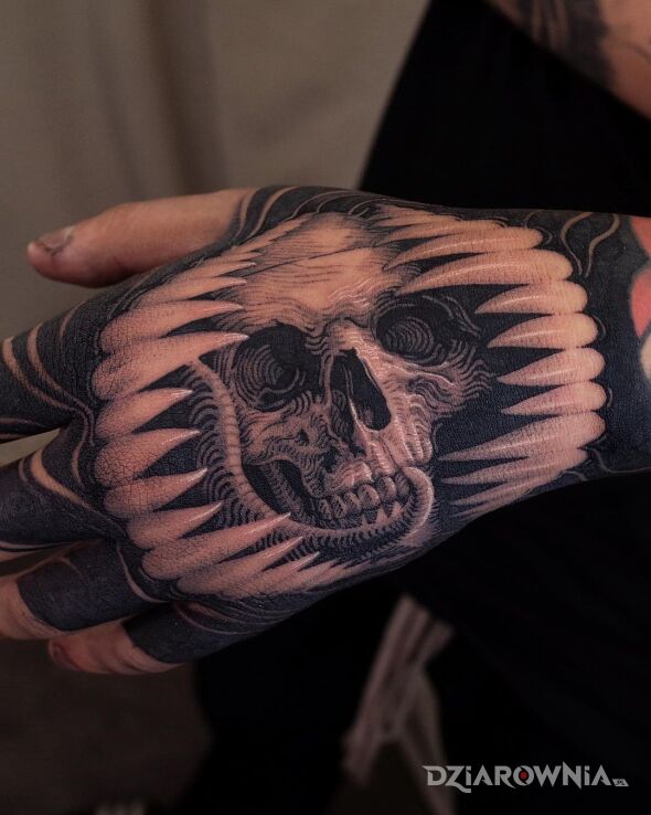 Tatuaż czaszka w paszczy w motywie mroczne i stylu graficzne / ilustracyjne na dłoni