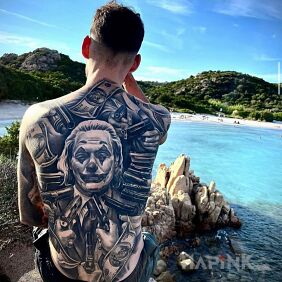 Tattoo Joker in the crosshairs on the shoulder blades motif: black and gray style: realistic