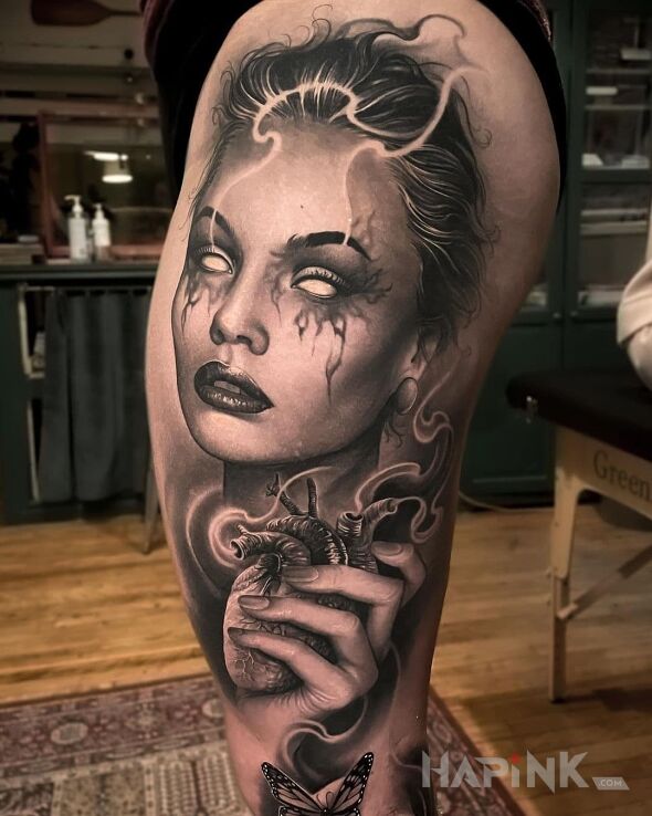Tattoo Serce w garści in faces motif and realistic style on the thigh