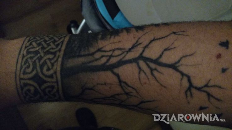 Tatuaż wikingowska bransoleta z lasem w motywie pozostałe na przedramieniu