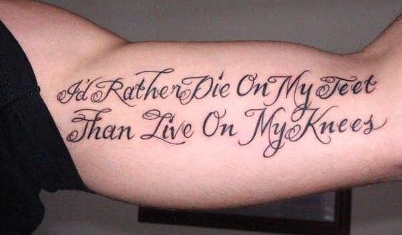 Tatuaż napis na bicepsie I'd rather die on my feet than live on my knees