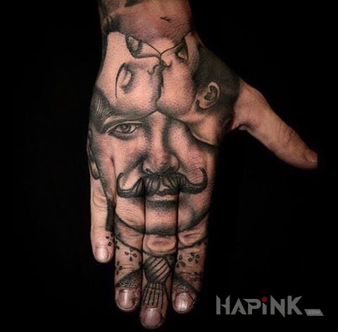 Tattoo Pan z wąsem in faces motif on the hand
