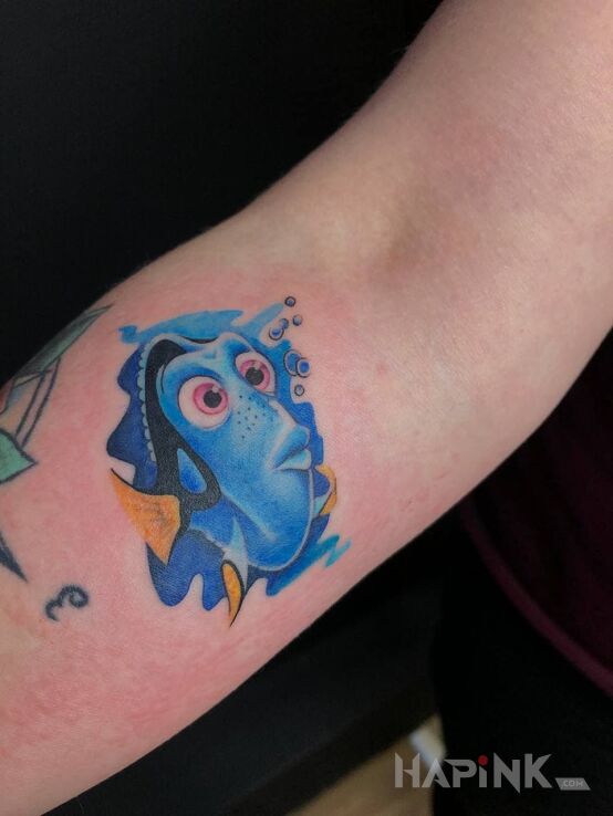Tattoo Rybka Dori in characters motif and cartoon / comic book style on the forearm