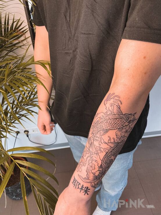 Tattoo Japonese fish in black and gray motif and japanese / irezumi style on the forearm