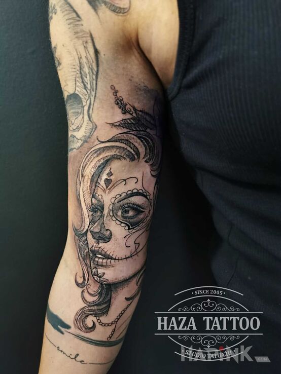Tattoo Santa muerte in faces motif and realistic style on the bicep