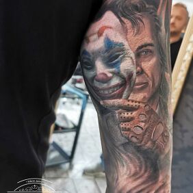 Tattoo Clown mask man On the arm motif: faces style: realistic