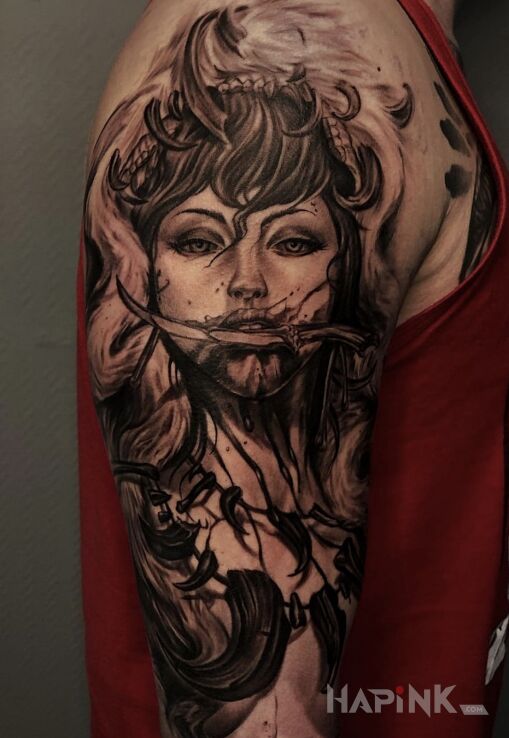 Tattoo Kobieta in dark motif and realistic style on the upper arm