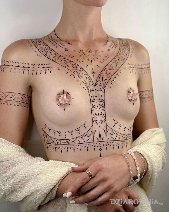 Tatuaż ornamentowo i minimalistycznie w motywie ornamenty i stylu kontury / linework pod piersiami (underboob)