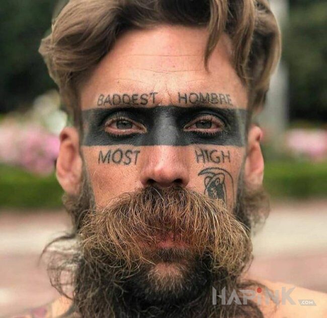 Tattoo Baddest hombre in lettering motif and blackwork / blackout style on the face