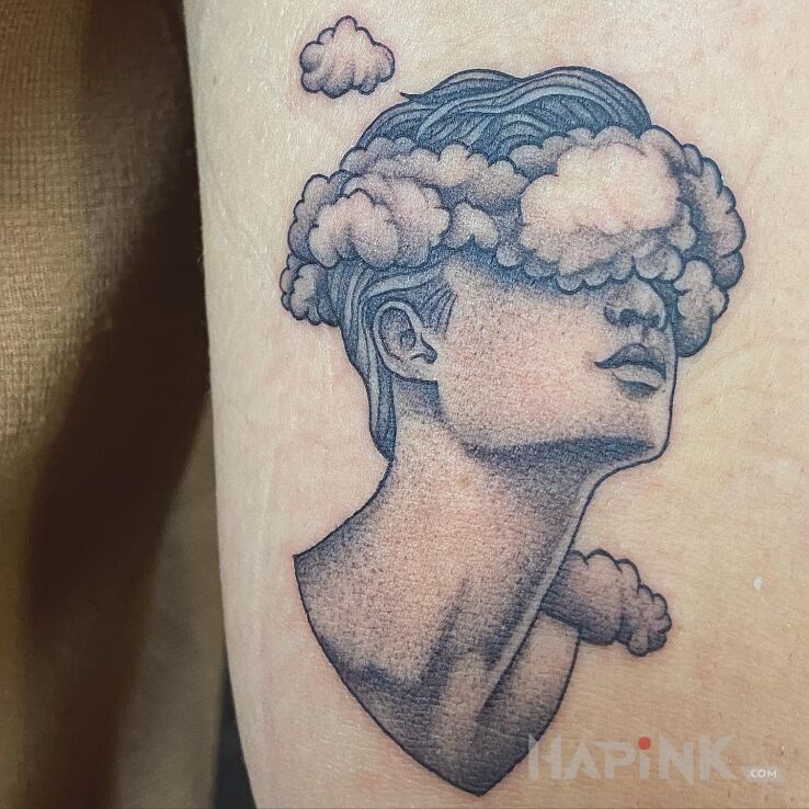 Tattoo Microrealism / Głowa w chmurach in black and gray motif and graphic / illustrative style on the upper arm