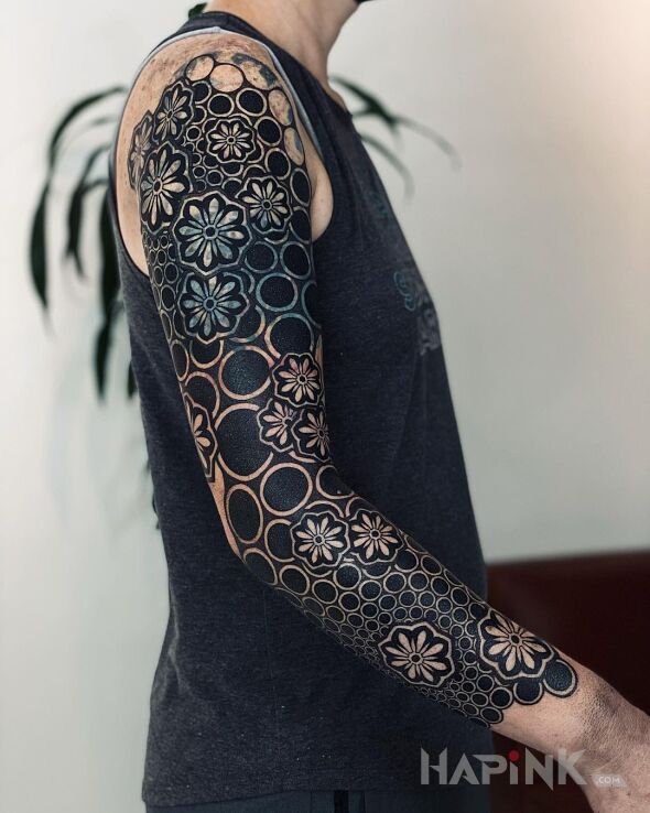 Tattoo Jakimi grasz? Oczywiście, że czarnymi! in flowers motif and blackwork / blackout style on the upper arm
