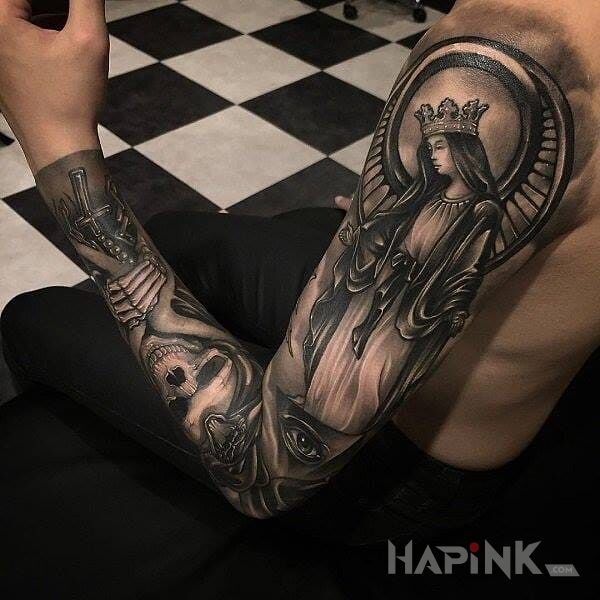 Tattoo Ave Maryja in skulls motif on the forearm