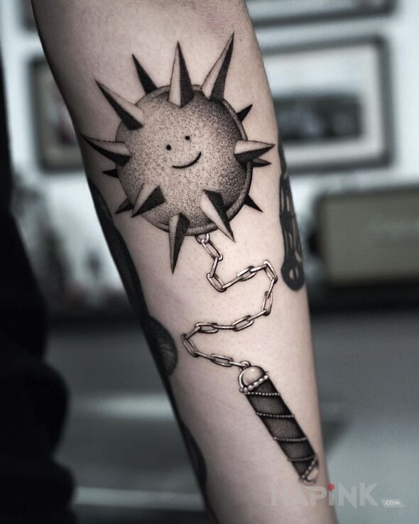 Tattoo Kolczasta kula in funny motif and realistic style on the forearm