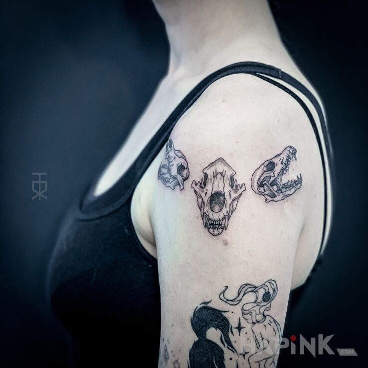 Tattoo Piesełki in black and gray motif and graphic / illustrative style on the upper arm