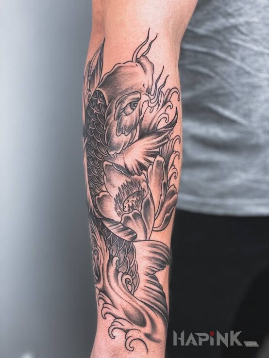 Tattoo Japonese fish in black and gray motif and japanese / irezumi style on the forearm
