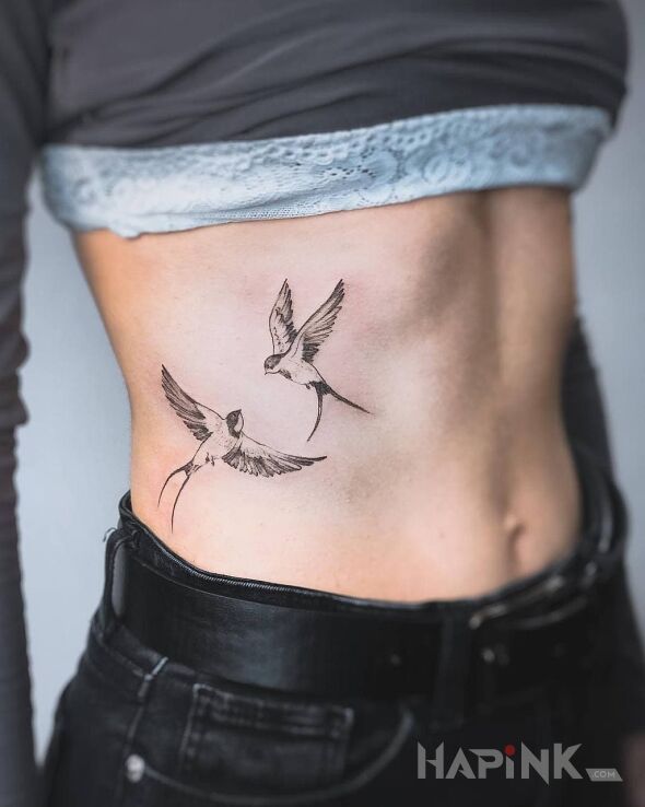 Tattoo Swallow in black and gray motif and graphic / illustrative style on the ribs