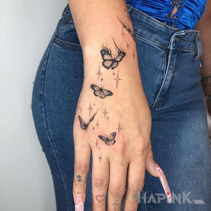 Tattoo 4 niewielkie motyle in black and gray motif and minimalistic style on the hand