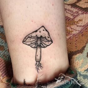 Tattoo Fly agaric mushroom near the ankle motif: black and gray style: graphic / illustrative