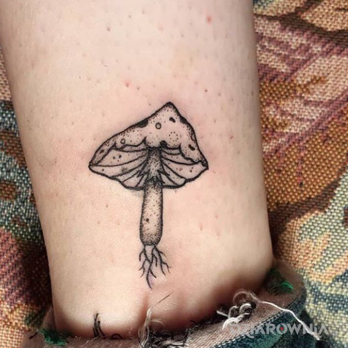 Tatuaż grzyb muchomor w motywie florystyczne i stylu dotwork przy kostce