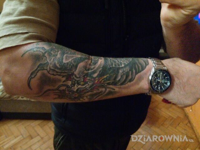 Tatuaż cover w motywie smoki na przedramieniu