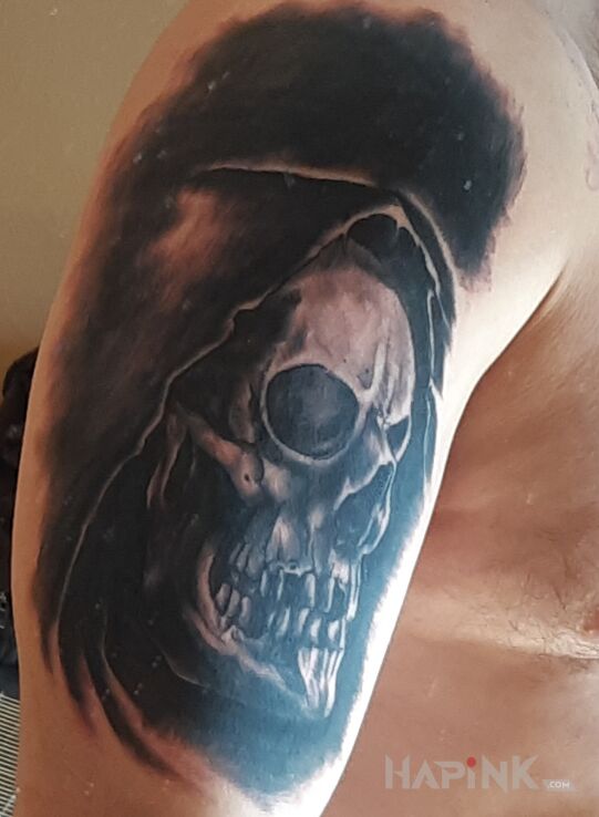 Tattoo Czacha w kapturze in black and gray motif and realistic style on the upper arm