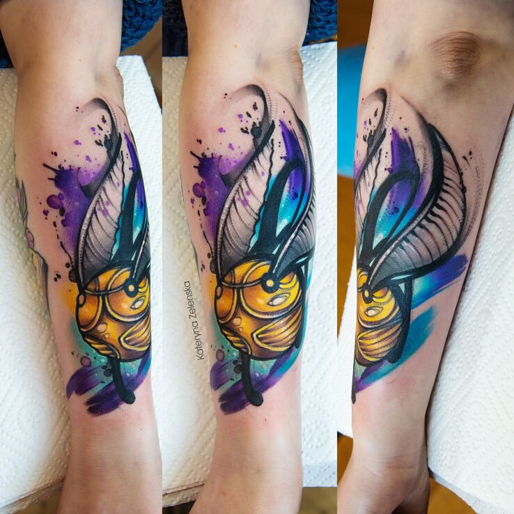 Tatuaż złoty znicz  piłka quidditcha  harry potter w motywie kolorowe i stylu watercolor na ręce