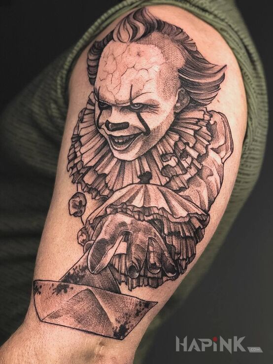 Tattoo Pennywise the dancing clown in black and gray motif and realistic style On the arm