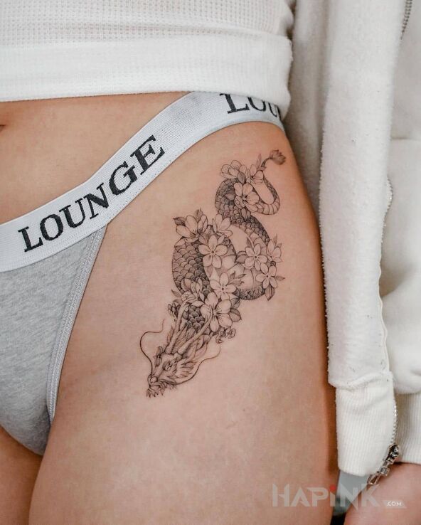 Tattoo Niewielki smok niosący kwiaty in flowers motif and graphic / illustrative style on the hip
