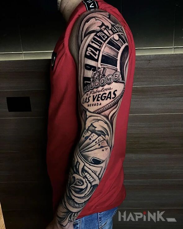 Tattoo Ruleta in black and gray motif and realistic style on the upper arm