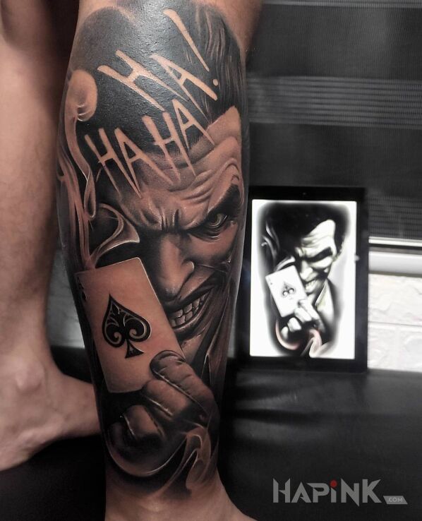 Tattoo Joker haha in black and gray motif and realistic style on the calf