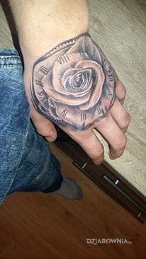 Tatuaż róża z zegarem w motywie kwiaty na dłoni