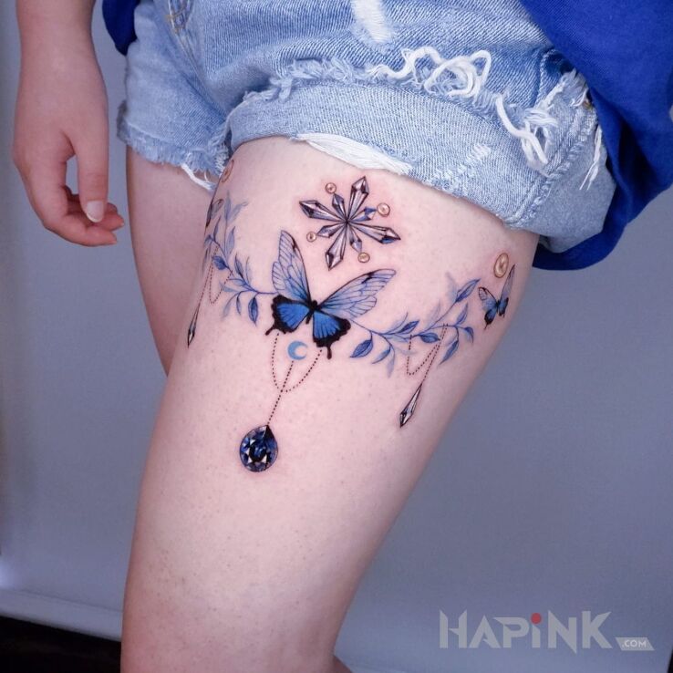 Tattoo Tatuaż na niebiesko in butterflies motif and graphic / illustrative style on the thigh