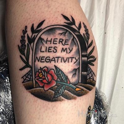 Tattoo Negatywne emocje w grobie in flowers motif and oldschool style on the calf