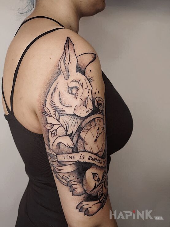 Tattoo Krolik in black and gray motif and graphic / illustrative style on the upper arm
