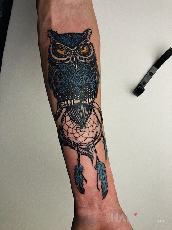 Tattoo Sowa in animals motif and abstract style on the forearm
