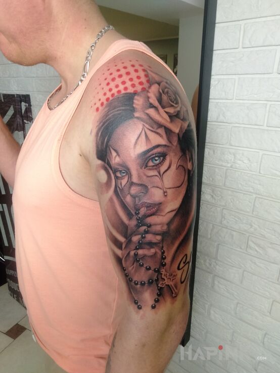 Tattoo Santa Muerte in faces motif and realistic style on the upper arm