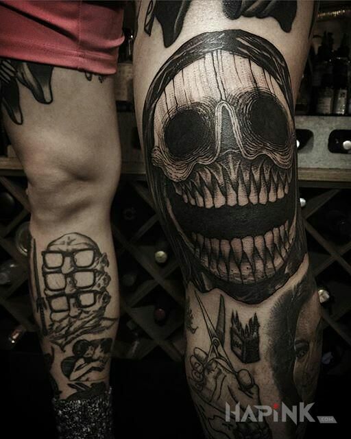 Tattoo Japa in faces motif and graphic / illustrative style on the knee