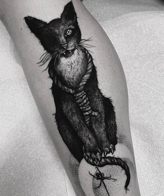 mroczny tatuaż kota na łydce
