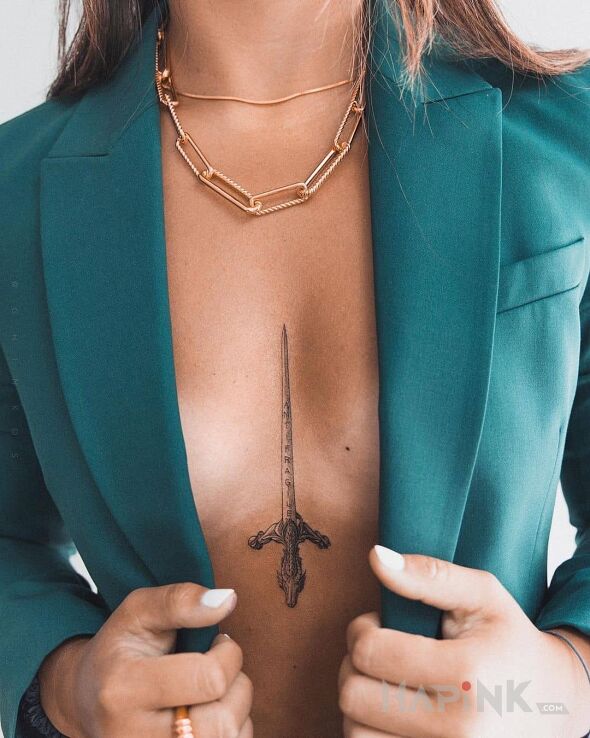 Tattoo Zasztyletowana in black and gray motif and graphic / illustrative style between the breasts