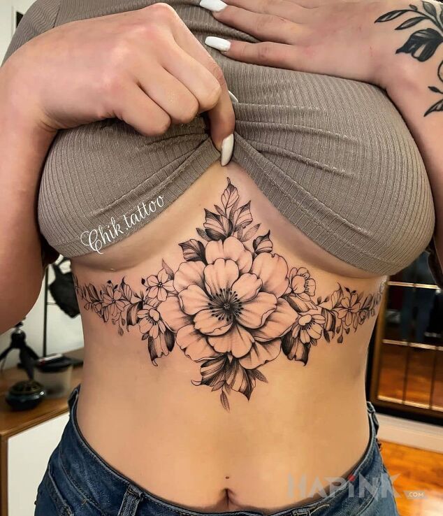 Tattoo Jeden duzy i pare mniejszych kwiatow in floral motif and realistic style underboob