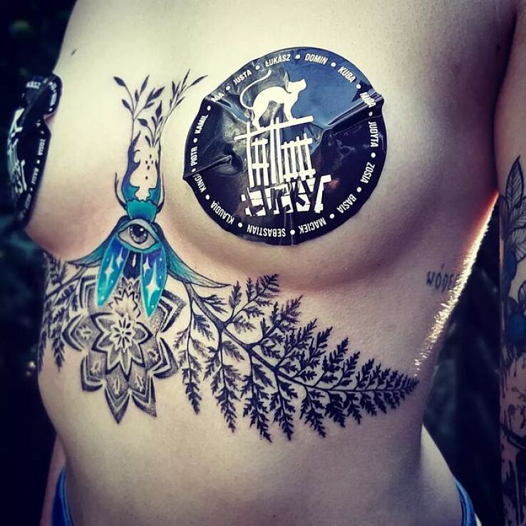 Tatuaż paprocie w motywie kwiaty i stylu dotwork pod piersiami (underboob)
