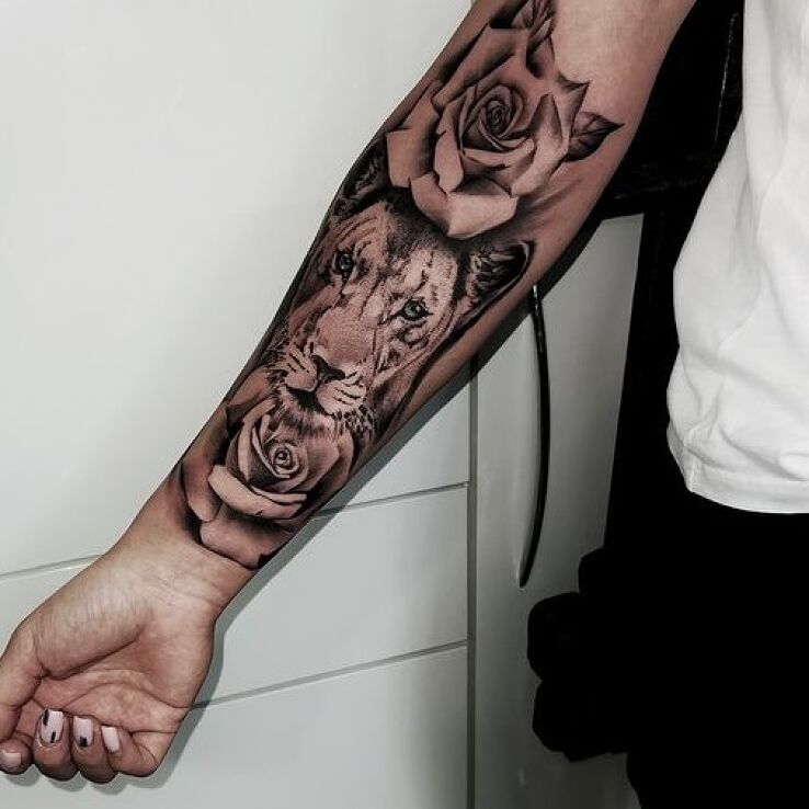 Tatuaż lwica w motywie florystyczne i stylu dotwork na ręce